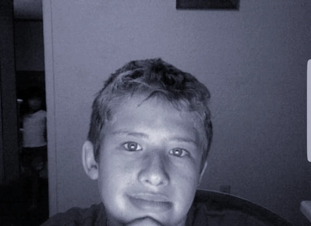My brother taking selfies on our desktop webcam circa 2008(?) What is that standing in the door behind him?